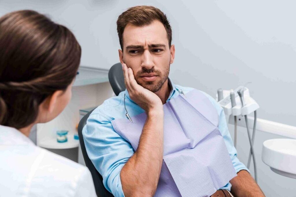 Patient discussing severe tooth pain with an emergency dentist during a dental visit